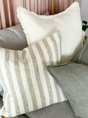 Eadie Lifestyle Luca white boho cushion with hand-frayed edging on grey sofa