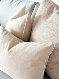 Soft beige norsuHOME Cushion Parissi Shell collection with feather down fillings on a gray sofa