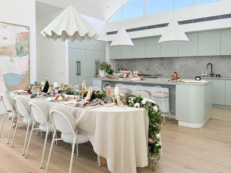 Dining table with L&M Terrace Oatmeal Tablecloth in a modern kitchen setting with festive decor.