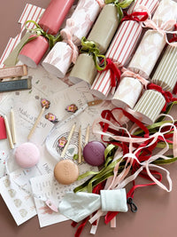 norsu Studio DIY Christmas Crackers set of six with velvet ribbons, gifts, paper hats, and festive decorations on a table