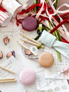 Set of six norsu STUDIO Christmas crackers with velvet ribbons and festive fillers on holiday-themed background