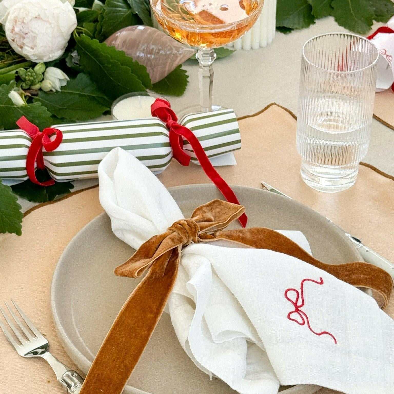Caramel velvet bow napkin ring from Same Time Tomorrow set on a white cloth napkin at table setting