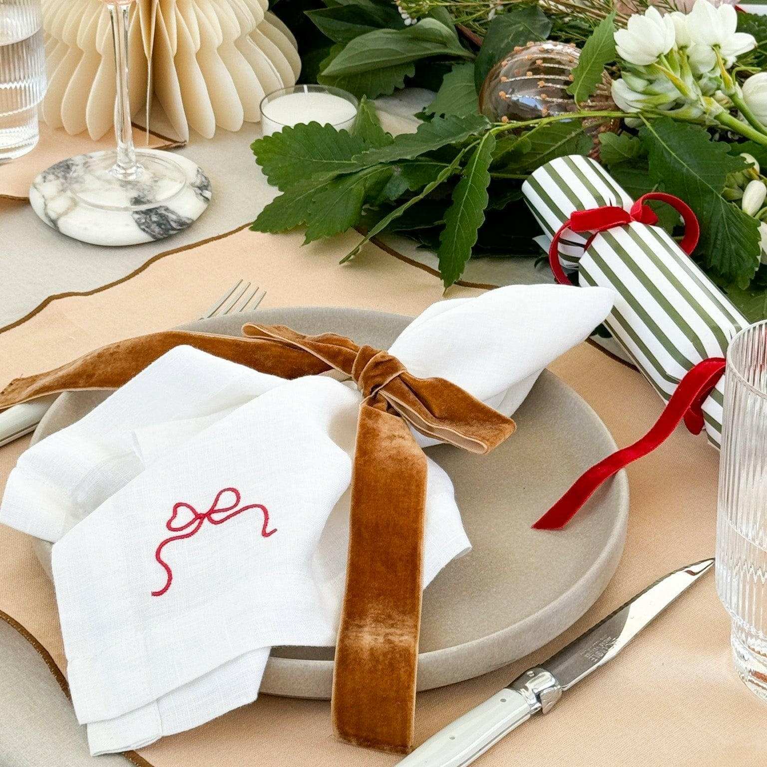 Set of six caramel velvet bow Same Time Tomorrow napkin rings on white embroidered napkins at elegant table setting