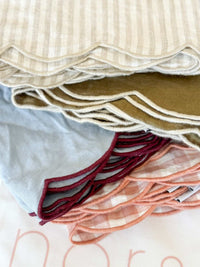 Set of 4 norsu Studio Linen scallop-edged napkins in blue with deep burgundy edge, made from 100% linen, 50x50 cm, with signature curved scalloped border and matching storage bag.