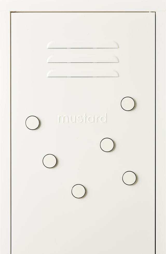 Set of six white Mustard Made The Buttons magnetic pins with smooth surface and embossed logo on the back, displayed on a white locker door.