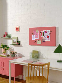 Berry color Story Board with magnetic surface mounted on white brick wall above a white desk in a pink and green themed room