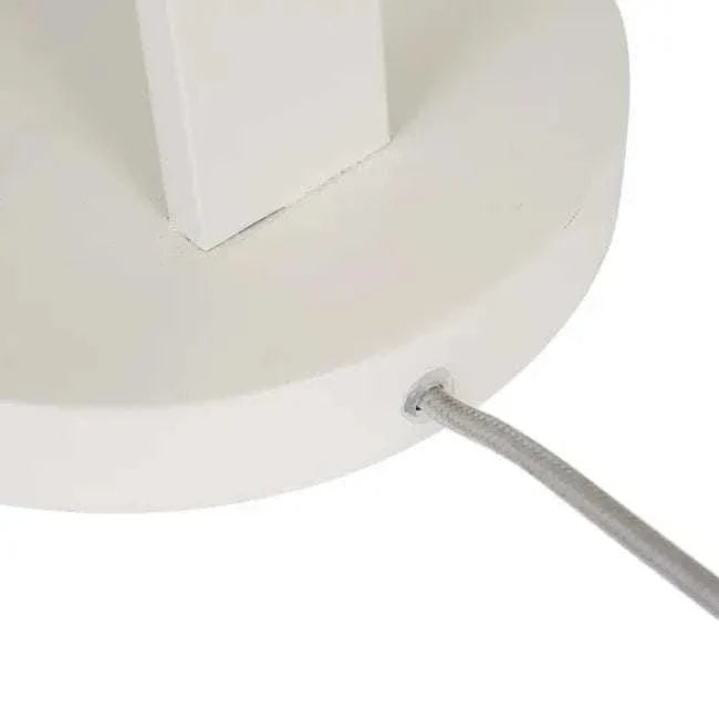 Close-up of the matt ivory iron base of the Easton Axel Desk Lamp with grey fabric cord attached.