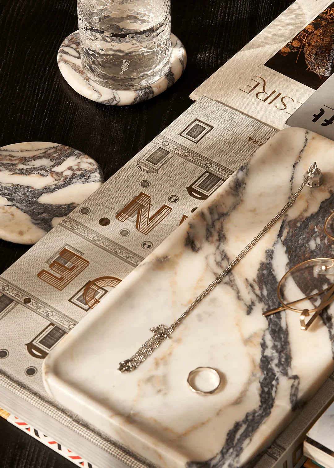 Linea Rectangle Marble Tray in Calacatta Viola marble with violet veins, styled with jewelry and accessories on a table setting
