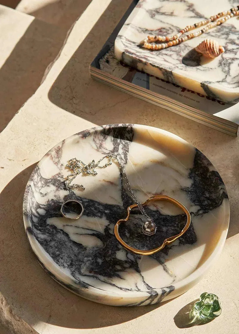 Linea Round Marble Tray in Calacatta Viola with violet veins holding jewelry on sunlight surface