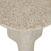 Close-up of Globe West Artie Outdoor Wave side table in warm sand fibrestone with a wave design and speckled texture