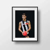 Framed Dom Gauci kids art print of Nick Daicos in Collingwood AFL uniform holding football on grey background