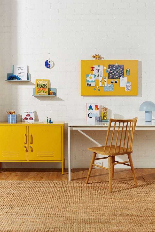 Yellow Mustard Made magnetic storyboard mounted on wall above desk with matching mustard lockers in stylish workspace