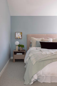 bedside table styled professionally with decorative items and soft furnishings