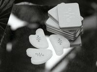 Set of By OliOli White Jade Sculpting Tools with signature tins on reflective surface