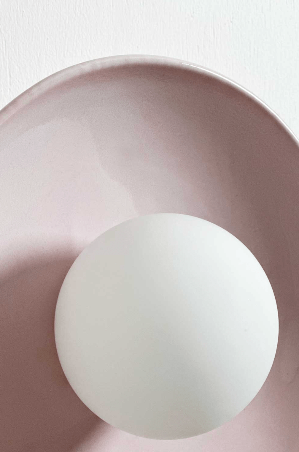 Robert Gordon Dish Wall Sconce in rose quartz ceramic with white globe light fixture