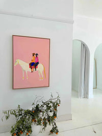 Oak framed Lottie Rae Smooth Operator fine art canvas print with abstract horse and riders on pink background in modern white room