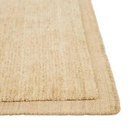 Close-up of GlobeWest Bower Frame Rug in butter color, hand-woven 100% wool with textured border detail