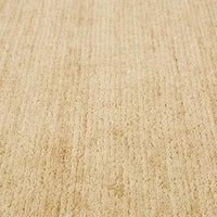 Close-up of GlobeWest Bower Frame Rug in butter color with hand-woven wool texture