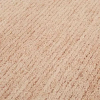 Close-up of GlobeWest Bower Frame Rug in rose color showing hand-woven wool texture