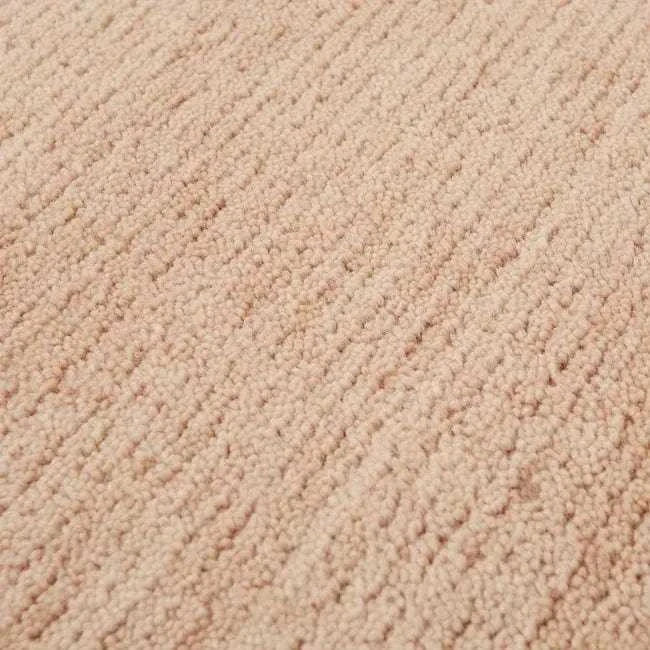 Close-up of GlobeWest Bower Frame Rug in rose color showing hand-woven wool texture