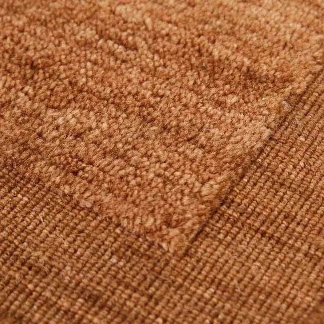 Close-up of GlobeWest Bower Frame Rug in rust color showing handwoven wool texture and framed design