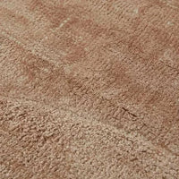 Close-up of GlobeWest Tepih Curve Rug in dusty rose with soft geometric pattern and handwoven texture