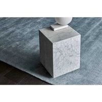 GlobeWest Tepih Tide Rug Marine close-up showing hand-woven viscose and wool ripple design with marble cube decor on dark wood floor