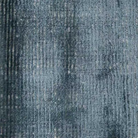 Close-up of GlobeWest Tepih Tide Rug in marine color with a textured ripple ocean-inspired handwoven viscose and wool design