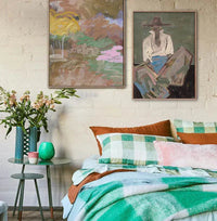 Marcia Priestley limited edition fine art canvas prints Chaps III in floating oak frames above cozy bed with green plaid bedding and bedside table with flowers and decor