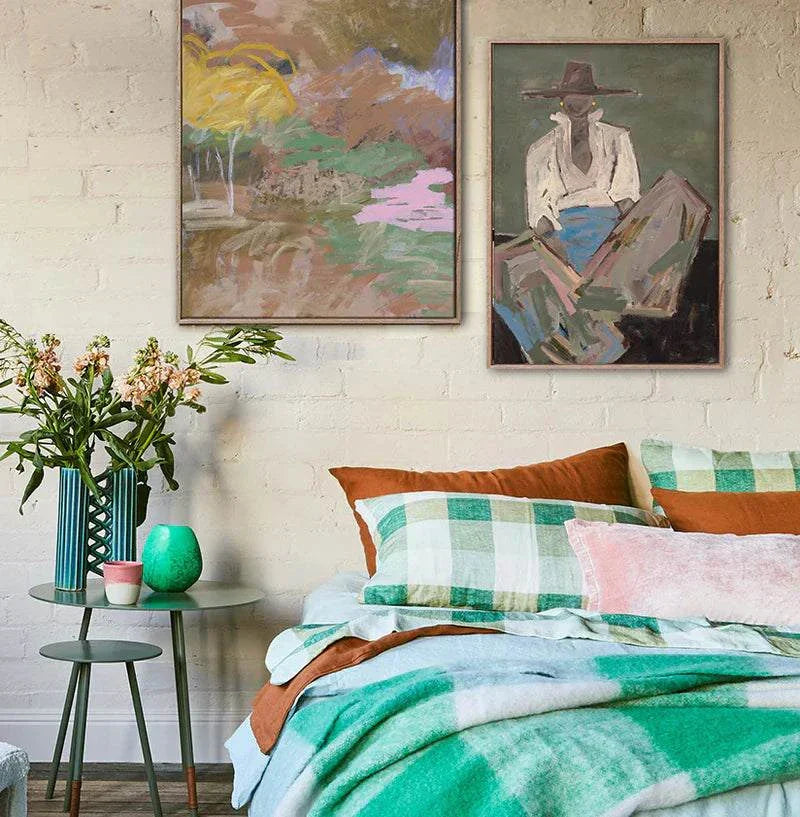 Marcia Priestley limited edition fine art canvas prints Chaps III in floating oak frames above cozy bed with green plaid bedding and bedside table with flowers and decor