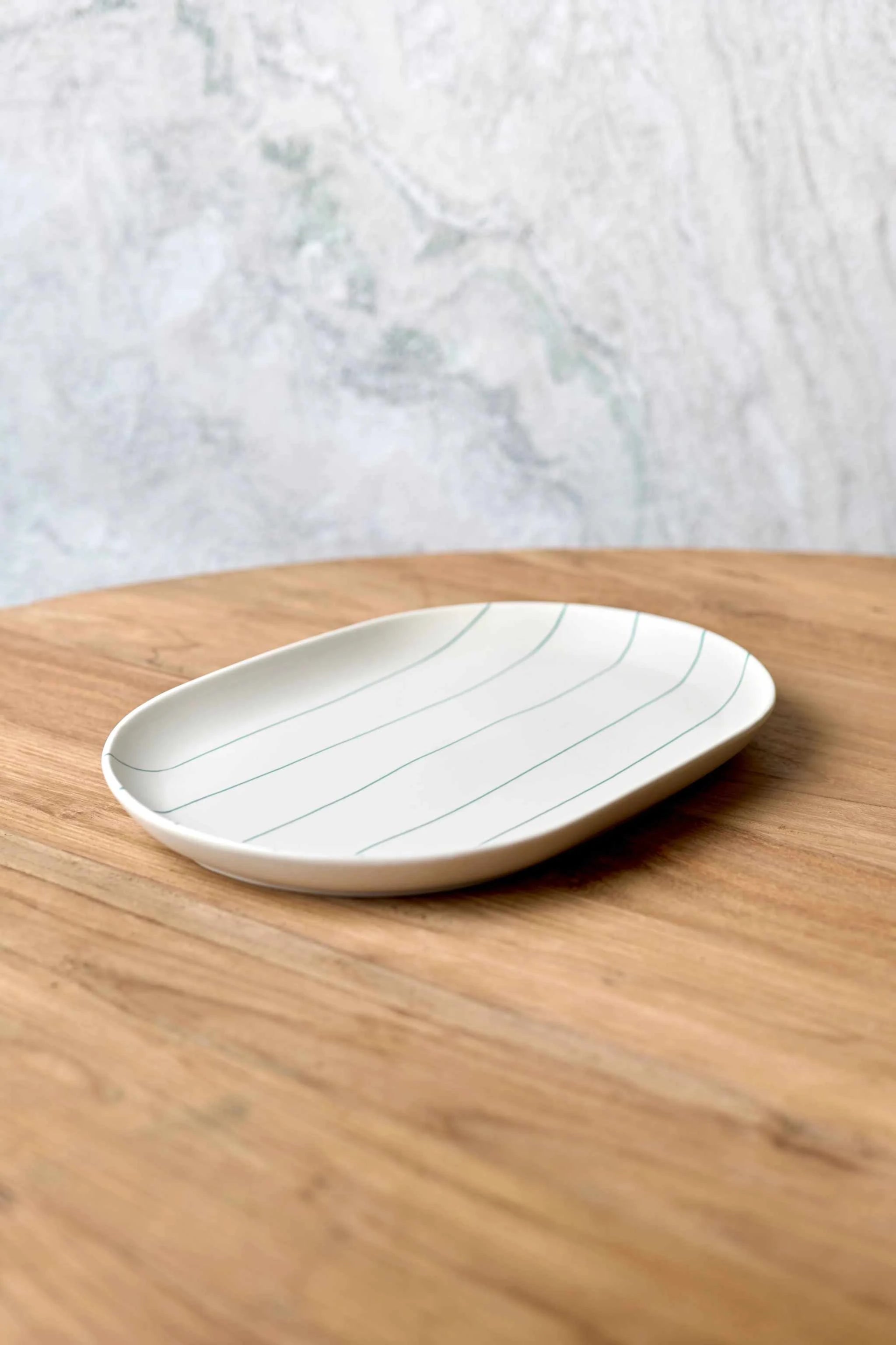 Robert Gordon Coastal Junction 38cm oval cream tray with green stripes on wooden surface