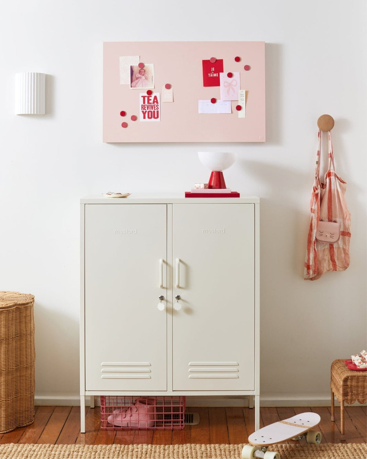 White locker with a pink bulletin board above it in a room setting.