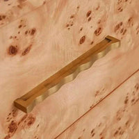 Close-up of gold-tone brass handle on light burl veneer surface of Trove Burl Bedside Table