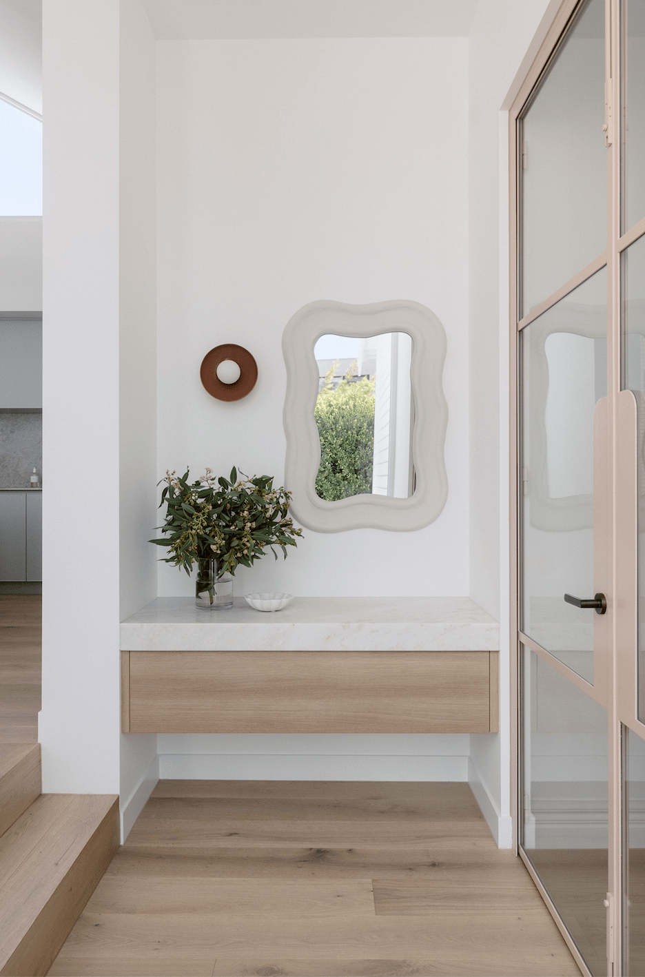 norsu x Robert Gordon Dusty Rose ceramic dish wall sconce mounted above wooden drawer in modern hallway