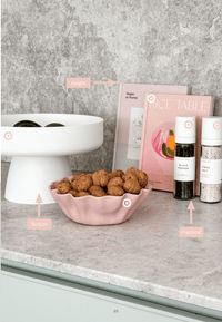 Kitchen countertop with decorative bowls, seasoning bottles, and cookbooks, featured in norsuHOME 2 Digital Magazine focusing on practical design and styling tips.