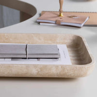 Beige CoTheory Travertine footed letter tray holding notebooks on a white desk