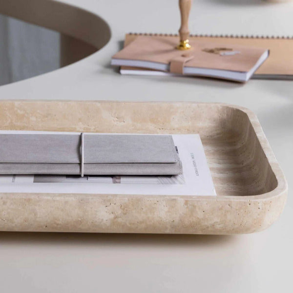 Beige CoTheory Travertine footed letter tray holding notebooks on a white desk