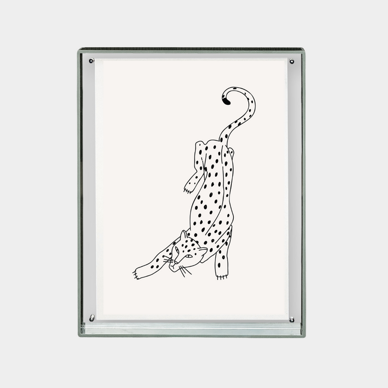 Minimalist black and white digital print of a stretching spotted leopard on a white background in a glass frame