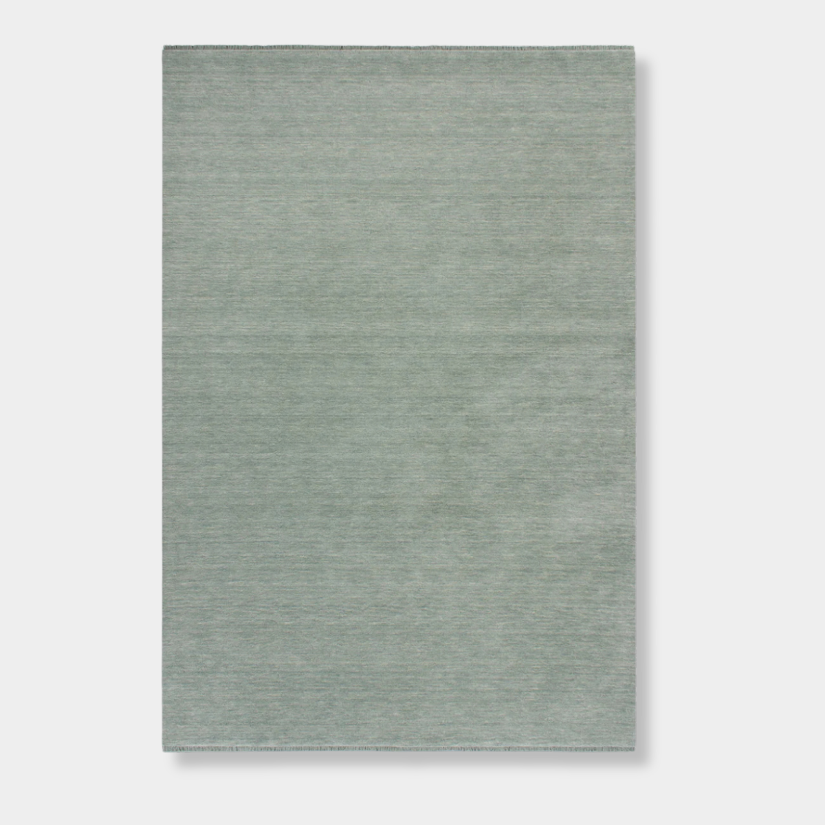 Baya Sandringham Floor Rug in aquamarine with a dense, hand-knotted wool pile and delicate fringed edges