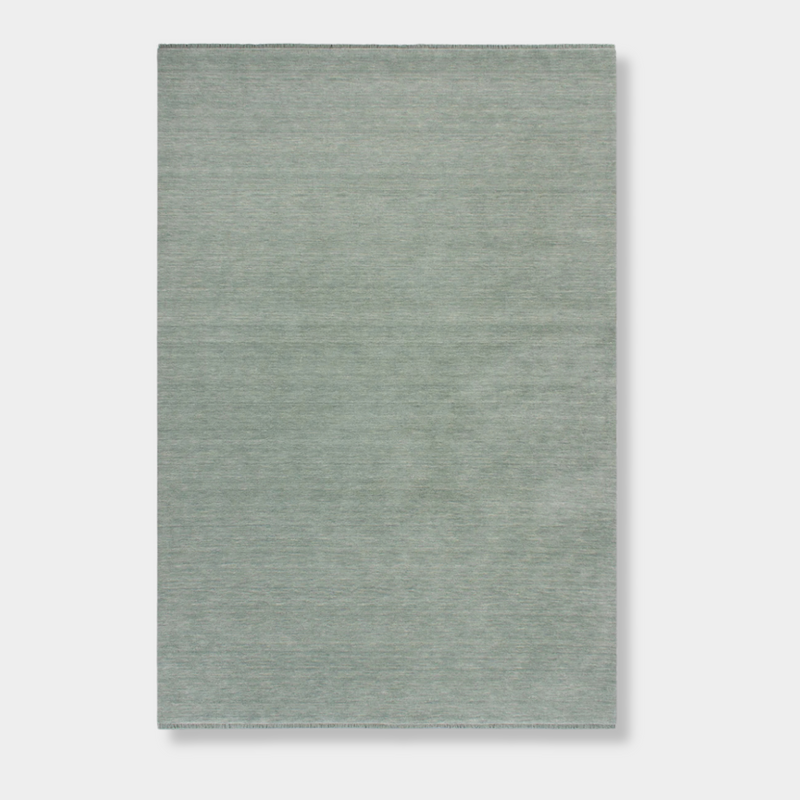 Baya Sandringham Floor Rug in aquamarine with a dense, hand-knotted wool pile and delicate fringed edges
