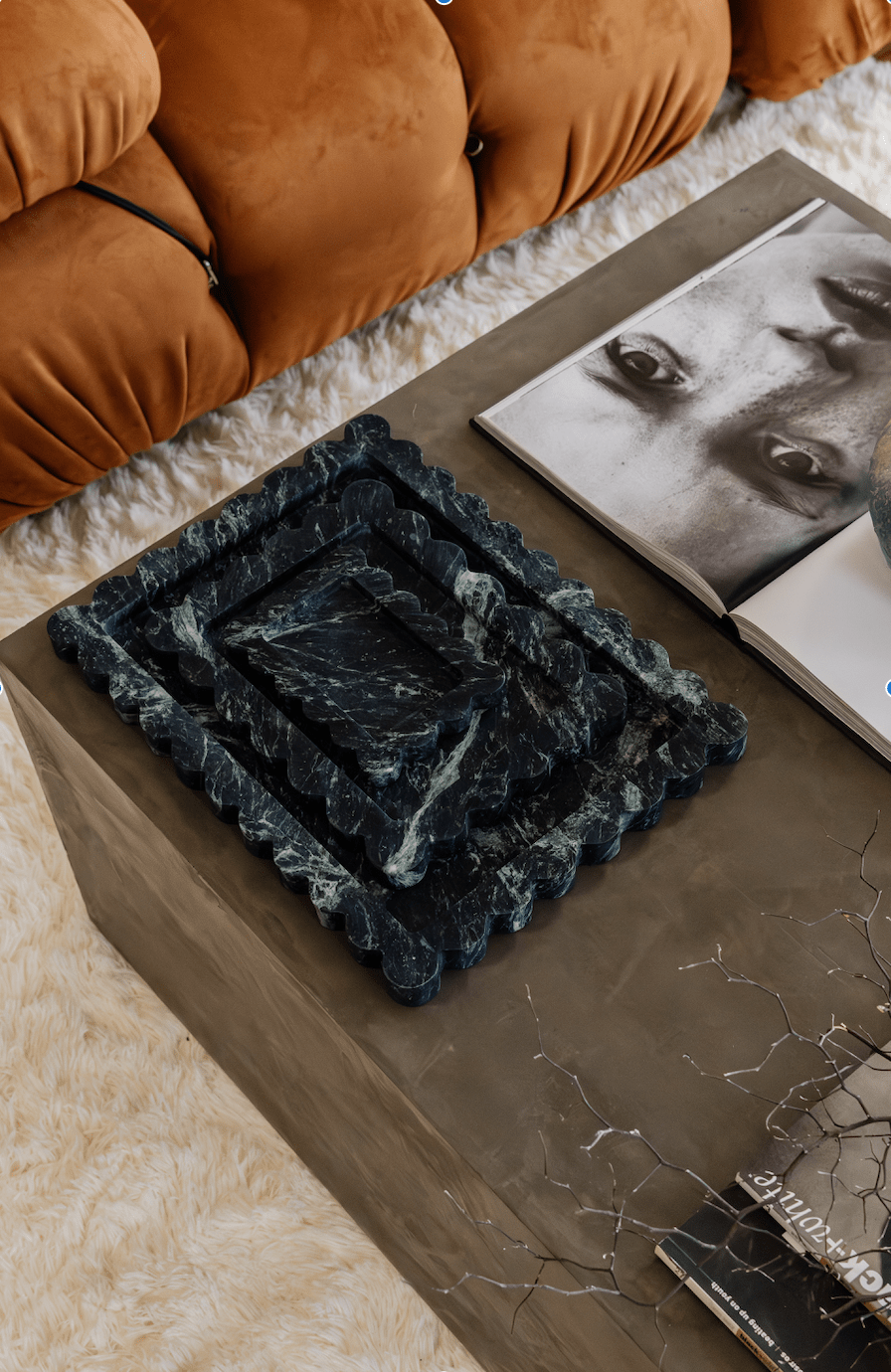 CoTheory Marble Tray large scalloped black Verdi Alpi marble on coffee table next to book and orange sofa