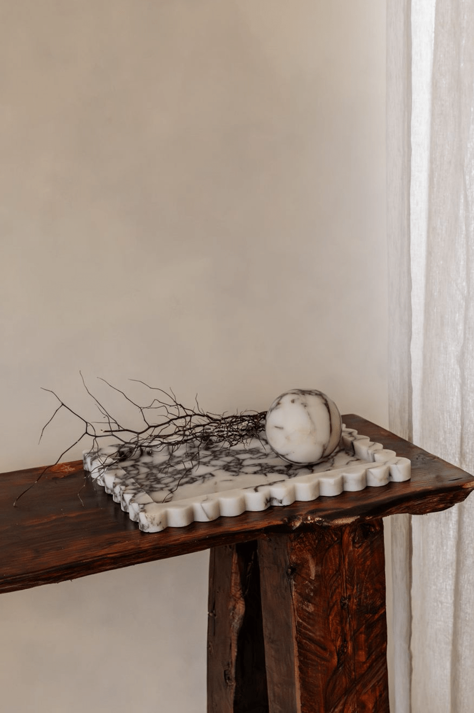 Palazzo Scalloped Marble Bar Tray large scalloped white and gray marble tray on wooden surface with decorative stone and branches