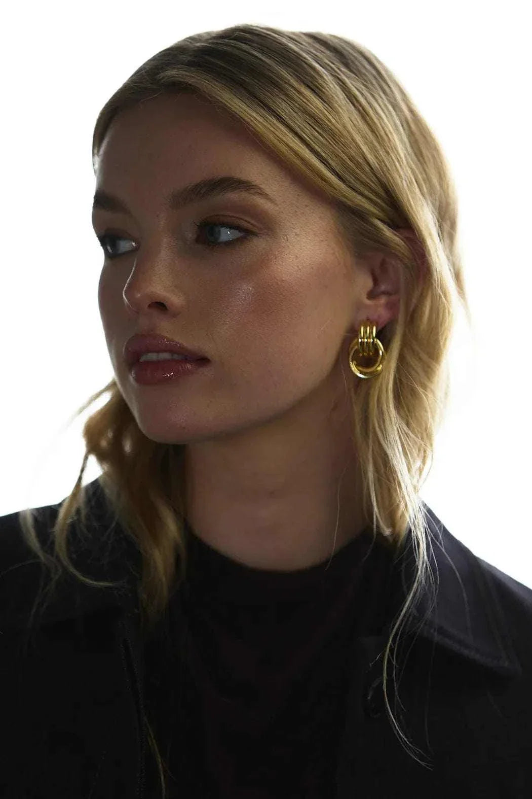 Woman wearing gold Zafino Poppy small hoop earrings with elegant design.