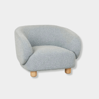 GlobeWest Flo occasional chair in Nimbus upholstery with natural ash wood legs, featuring wraparound back and modern design