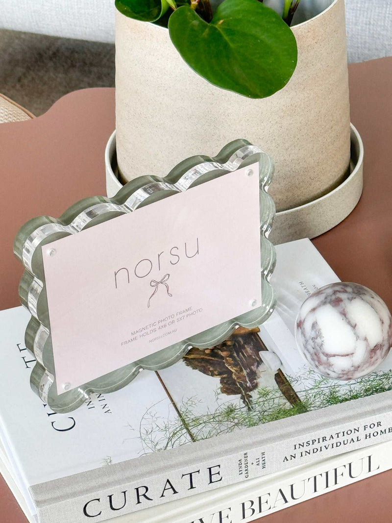 norsu Studio scalloped magnetic photo frame with sage background on stylish home decor setup