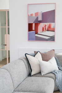 Aura cushion in a styled living room with artwork above the sofa