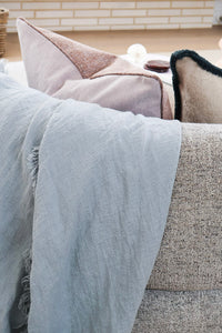 Aura cushion lilac side up with a soft blue linen throw