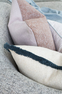Aura Reversible Cushion corner folded to show the terracotta weave and lilac linen reverse