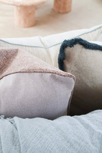 Both faces of the Aura Reversible Cushion, terracotta and soft lilac