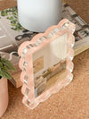 norsu Studio Scalloped Magnetic Photo Frame in blush with clear acrylic edges, displayed on a table with books and plants, showcasing its modern gallery-style depth and magnetic closure design